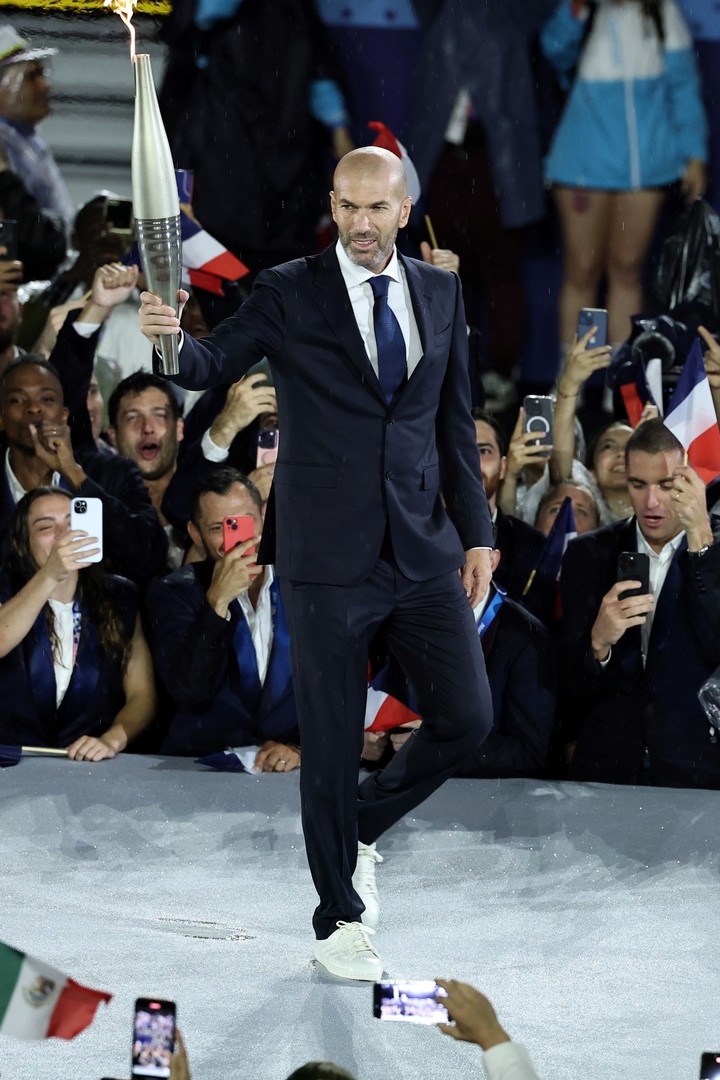 Paris (France), 26/07/2024.- French former soccer player Zinedine Zidane holds the Olympic torch during the Opening Ceremony of the Paris 2024 Olympic Games, in Paris, France, 26 July 2024. (Francia) EFE/EPA/CHRISTOPHE PETIT TESSON / POOL