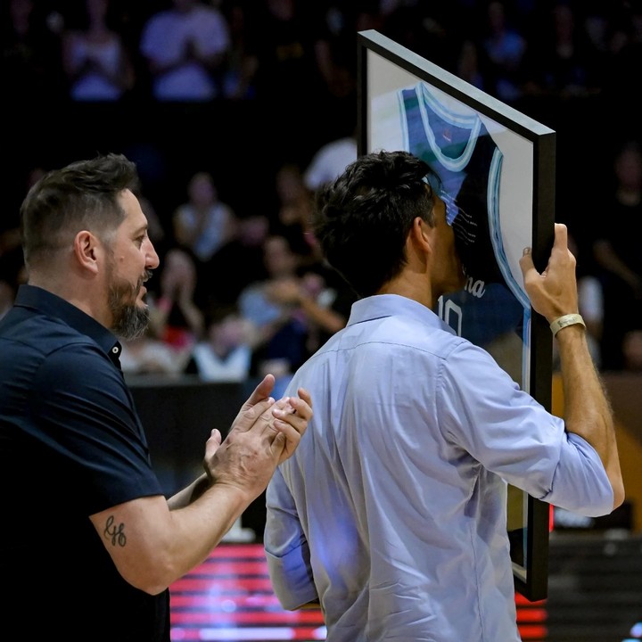 Beso a la camiseta enmarcada por parte de Delfino, el último jugador de la Generación Dorada en retirarse. (Prensa CAB)
