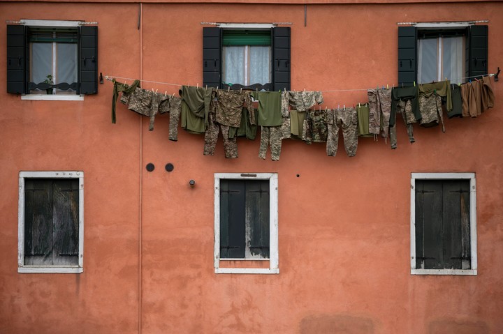 Una instalación artística que representa uniformes militares colgados de un tendedero en Venecia, Italia. Foto: EFE/EPA/ZOLTAN BALOGH HUNGARY OUT