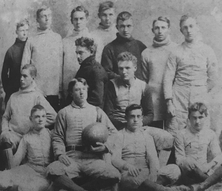 Charles Ives, capitán de fútbol en la escuela, pelota en mano.
