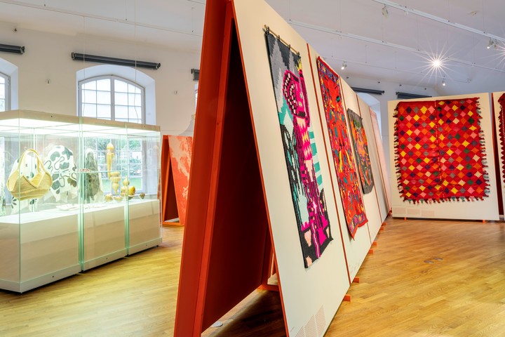 Baetones contemporáneos del proyecto "Como llegan las flores a las telas" de Constanza Martínez y de artesanas teleras de Santiago del Estero de la Colección Privada de Ricardo Paz, Galería Herlitzka (Argentina). En las vitrinas, la cestería de carandillo correntino de Maydi y el biodiseño con calabaza-mate de Rerere (Argentina) y los ponchos de lana de oveja de la Cooperativa Manos del Uruguay.